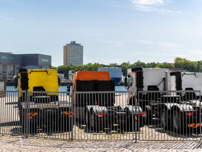 Back view many new heavy commercial cargo transport vehicles stand at port for export import